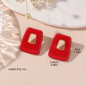Retro red square geometric earrings with gold trim on an elegant white display tray