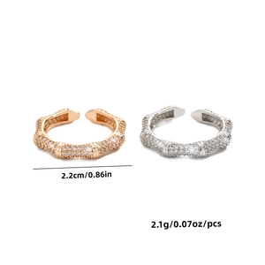 Detail of adjustable bamboo-style rings with crystals and size metrics in white back