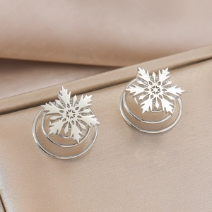 Détail macro de boucles d'oreilles flocon argentées avec base spirale à trois niveaux