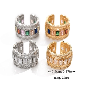 Détail de quatre bagues en zircon avec gravures de dentelle et cristaux multicolores brillants