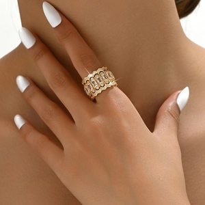Gros plan sur une bague dorée de luxe avec zircons rectangulaires et détails filigranes
