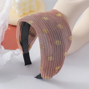 Détail du serre-tête en tissu plissé champagne avec des pois pailletés dorés brillants