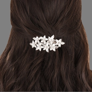 Luxurious silver flower hair clip with diamonds on wavy brown hair from a back view