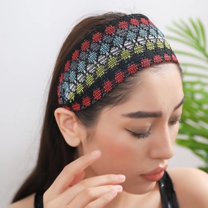 Fashionable wide knitted headband with colorful polka dots on black fabric for women