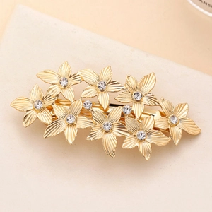 Macro shot of gold floral spring hair clip with radiant petals and sparkling rhinestones