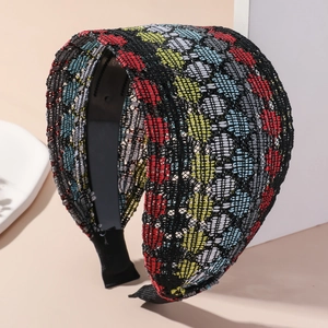 Detail of multi-color woven wide headband with ethnic geometric pattern and black lining