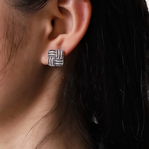 Élégantes boucles d'oreilles carrées tressées en argent avec zircons sur un mannequin