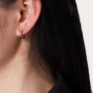 Minimalist double-hoop cross earrings in polished gold finish shown on model