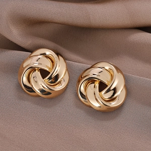 Elegant twisted gold knot earrings on luxury brown satin background for women