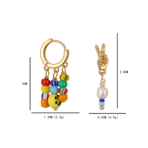 Asymmetric beaded smiley face and peace sign earrings with pearls in gold finish