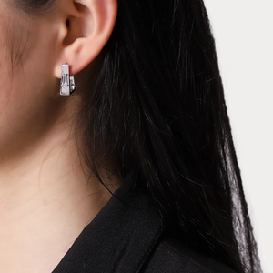 Boucles d'oreilles géométriques argentées avec zircon rectangulaire sur modèle asiatique