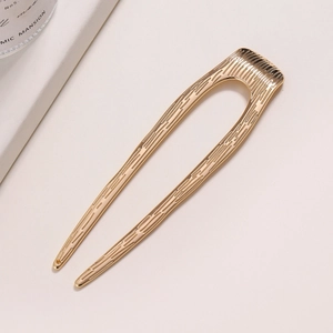 Eleganter goldener U-förmiger Haarnadel aus Metall mit vertikalem Streifenmuster auf Weiß