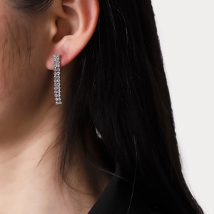 Elegant long tassel drop earrings with sparkling diamonds on a female model