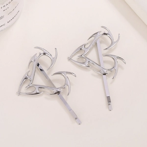 Dettaglio di due fermagli a cuore in lega d'argento con design metallico traforato