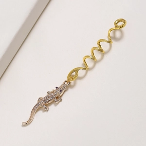 Détail d'un anneau de cheveux crocodile avec strass argentés et spirale dorée