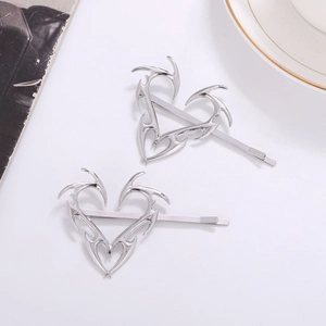 Fermagli per capelli in metallo argento con cuore di spine in un ambiente sobrio