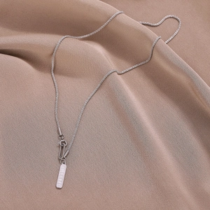 Minimalist silver Fillette rectangle pendant necklace on soft fabric background