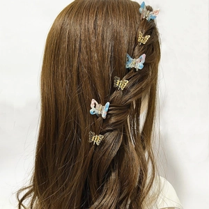 Mini butterfly hair clips in gold metal and marble resin on brown braided hairstyle