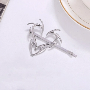 Fermaglio per capelli in metallo argento con cuore di spine su sfondo bianco puro