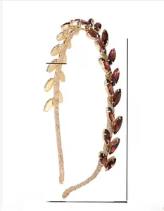 Détail du serre-tête branche d'olivier dorée avec cristaux rouges et dimensions 13,5x11,5 cm