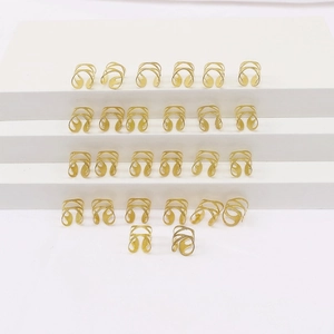 Golden hollow metal hair rings for braids and ponytails on a white display stand