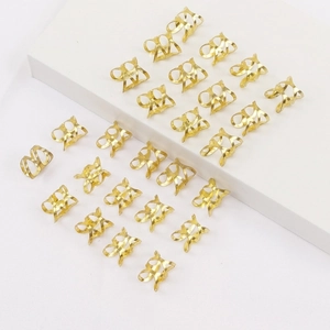 Set of 20 golden hollow dreadlock rings and hair charms on a minimalist white stand