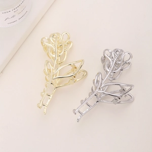 Vista detallada de pinzas para el cabello de metal con forma de rosa en oro y plata