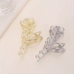 Detalle de pinzas de metal para el pelo en oro y plata con diseño de rosas caladas finas