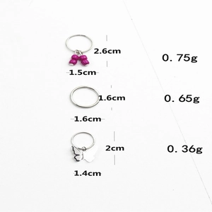 Detalle de anillos metálicos para el cabello con cuentas púrpuras y colgante de mariposa