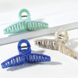 Three elegant Morandi colored large hair claw clips in mint green, navy blue, and ivory marble