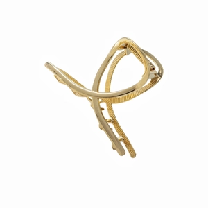 Pinza per capelli minimalista in metallo dorato con design ad arco incrociato su fondo bianco