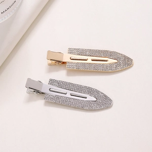 Elegant gold and silver rhinestone duckbill hair clips on minimalist cream background