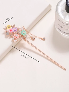 Detailed macro view of vintage flower hair pin with tassels and inlaid rhinestones