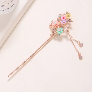 Detailed macro view of rose gold floral hair pin with crystals, pearls and long tassels