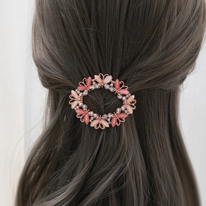 Detailed view of an elegant hollow butterfly hair clip with pink rhinestones on hair