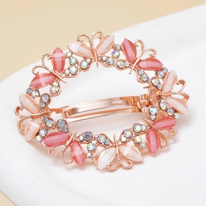 Close-up of rose gold butterfly hair clip with opal-effect resin and sparkling crystals
