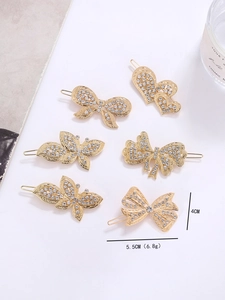 Détail d'un lot de six barrettes dorées en métal avec strass en forme de papillon et cœur