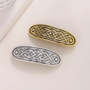 Detail view of retro Celtic knot metal hair clips in antique gold and silver finish
