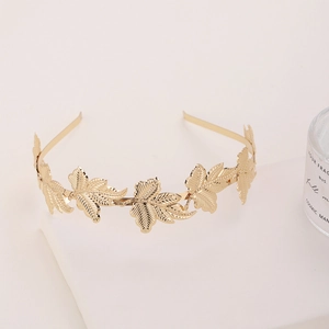 Baroque style golden metal leaf headband with fine maple leaf textures on white stand