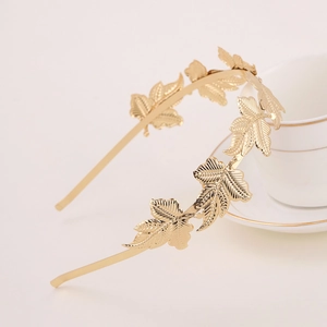 Detail of elegant gold baroque leaf headband resting on a vintage white porcelain cup