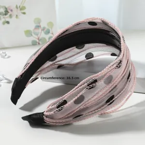 Détail d'un serre-tête large en mesh rose à pois noirs avec circonférence de 38,5 cm