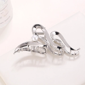 Macro shot of silver wavy hair claw clip with pearl detail and premium metallic finish