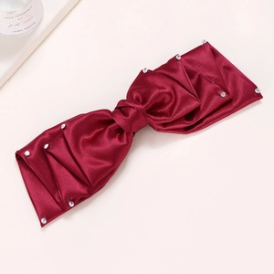 Texture détaillée du nœud papillon en satin bordeaux avec cristaux scintillants