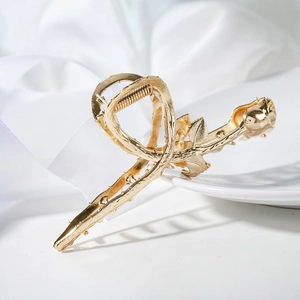 Elegant gold rose flower hair claw clip with metallic leaves on white silk background