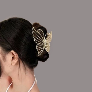 Pince à cheveux papillon en métal doré élégant présentée sur une chevelure