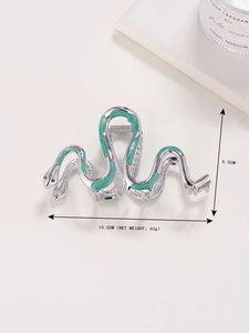 Detail view of a 10.5cm silver snake hair claw with green enamel and emerald crystal eyes