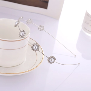 Dettaglio cerchietto fiori argento con strass e perle su tazza da caffè bianca
