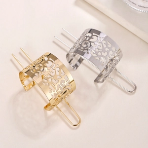 Detail view of gold and silver hollowed hair pins with elegant floral vine patterns