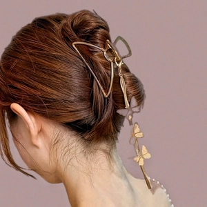 Elegante pinza per capelli a farfalla in metallo dorato con lunghi pendenti a nappa