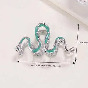 Silver metal snake hair claw clip with green enamel and rhinestone eyes on white background